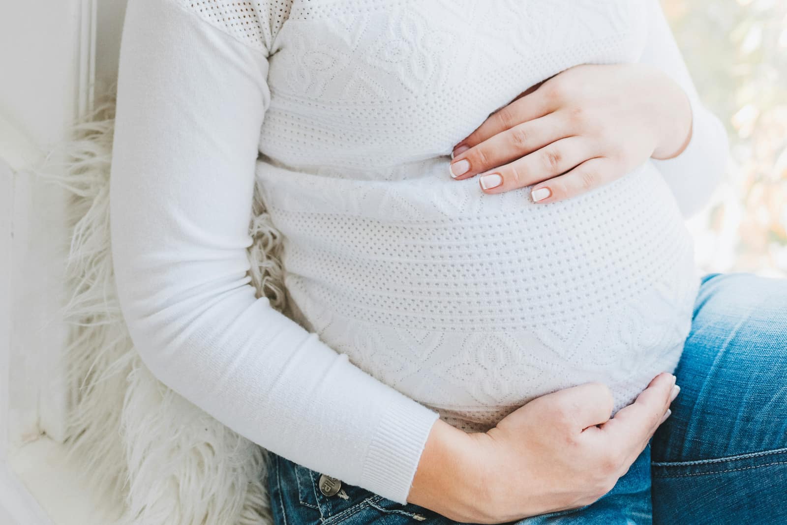 A quiet, warm-lit portrait suggesting pregnancy and expectant care